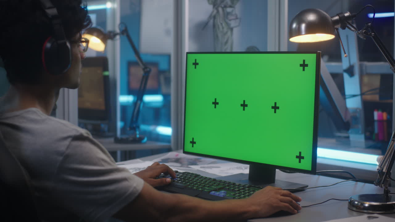 녹색 화면으로 컴퓨터에서 일하는 사람