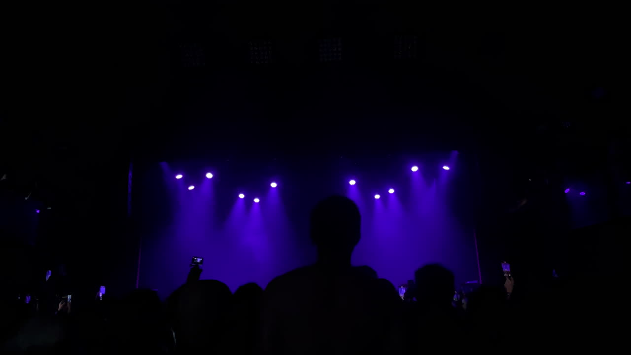 Effetti di luce drammatici illuminano una folla a un vivace evento di vita notturna con un'atmosfera energica