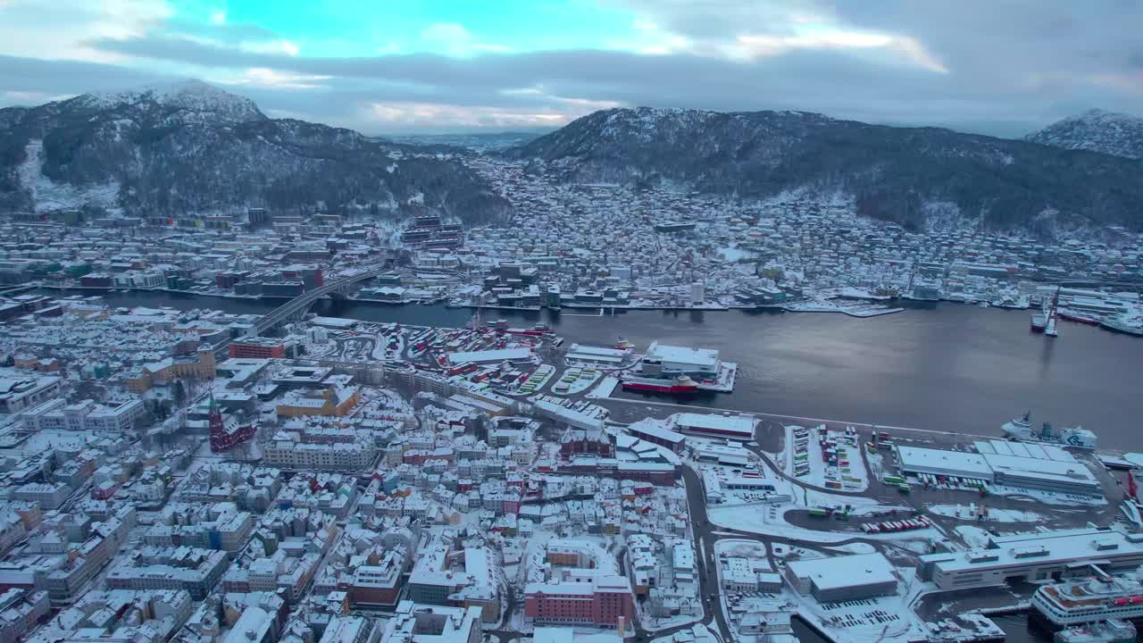 White snow covered city of Bergen, aerial view of port harbour, establishing