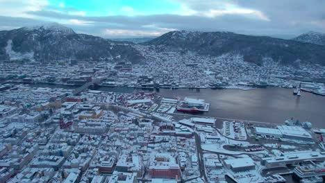 white snow covered city of bergen, aerial view of port harbour, establishing
