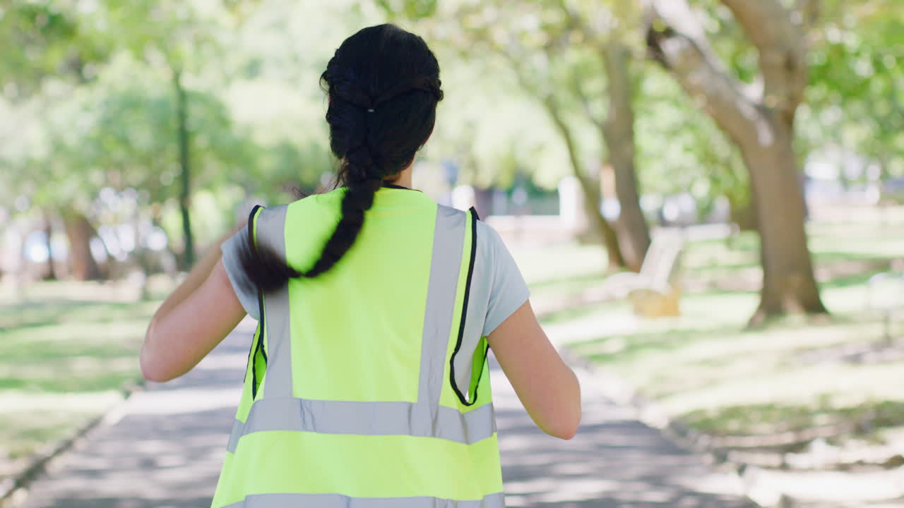 vista trasera de una mujer que se pone una seguridad reflectante