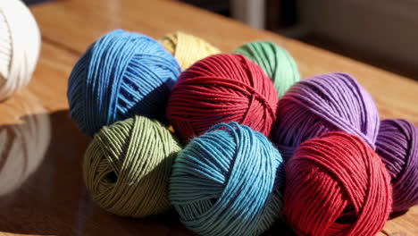 colorful yarn balls on wooden table