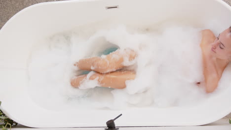 relaxing in bathtub, woman enjoying bubble bath at home