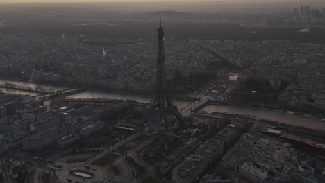 Aerial-footage-of-Eiffel-Tower-and-cityscape-at-dusk.-Tilt-up-reveal-of-colourful-twilight-sky.-Paris,-France