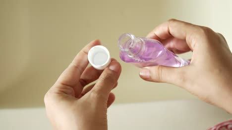 pouring liquid from a purple bottle