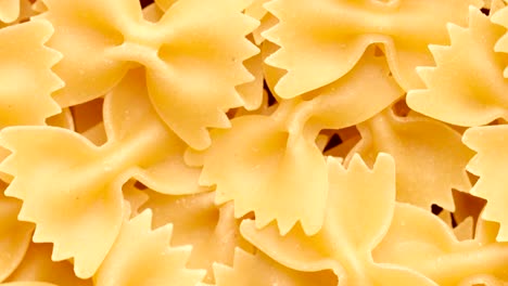 pale of raw italian farfalle pasta rotating in circle