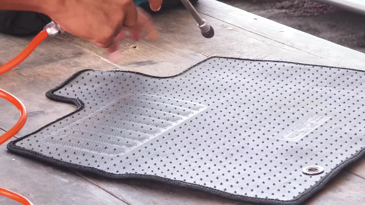 Cleaning a car floor mat with an air blower
