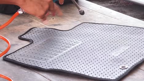 cleaning a car floor mat with an air blower