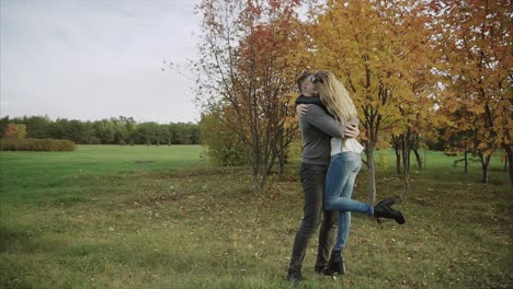 una pareja besándose en el parque de otoño.