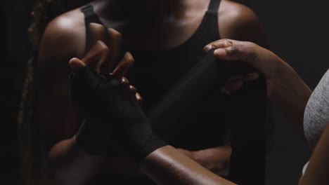 studio shot of women putting on boxing wraps on hands before exercising together 4