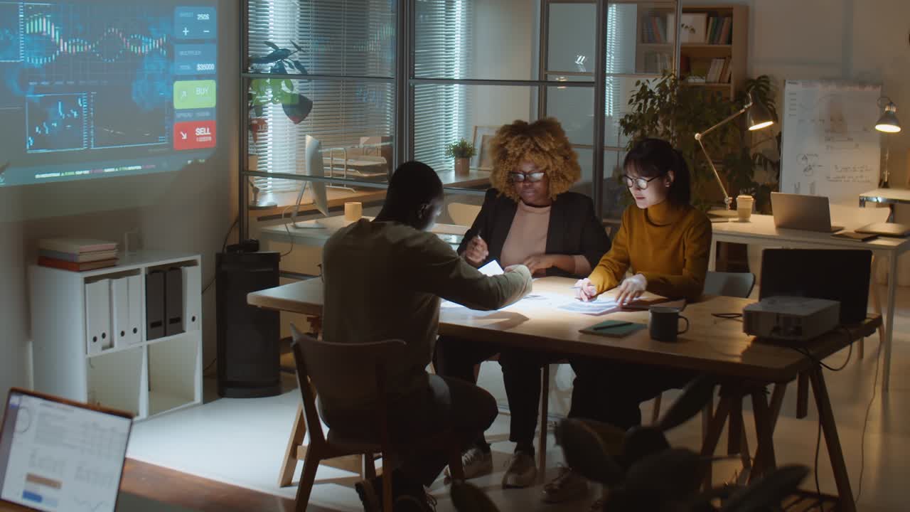 equipo empresarial multiétnico que trabaja en la oficina durante la noche