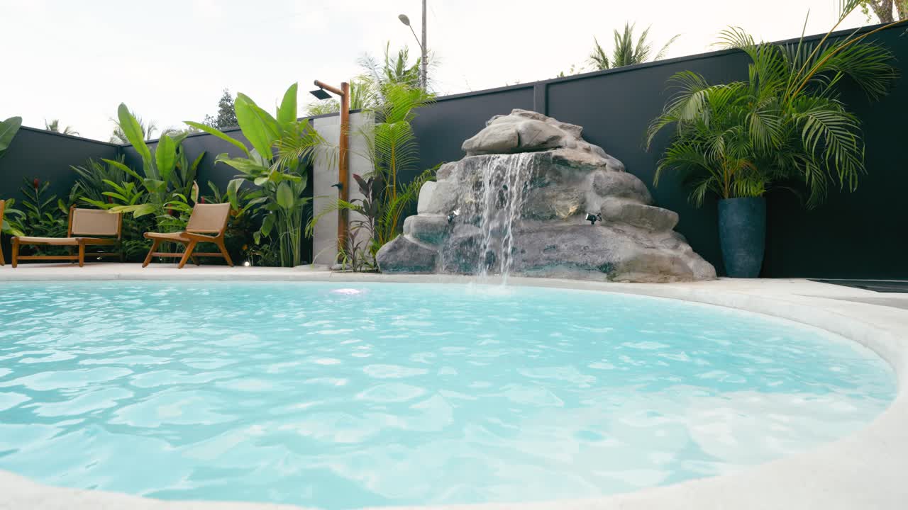 Luksus swimmingpool med vandfald og tropisk have