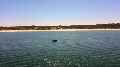 Amplia-órbita-Alrededor-De-Una-Pequeña-Lancha-Motora-Y-Un-Practicante-De-Wakeboard-Preparándose-Para-La-Acción.