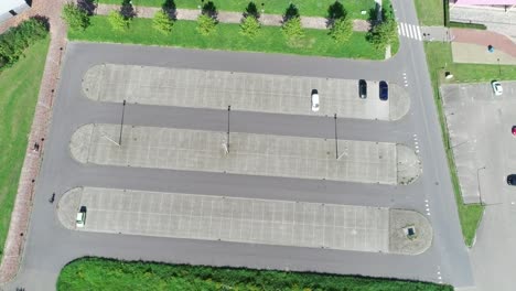 steady aerial drone shot of person bicyclist riding through a parking lot