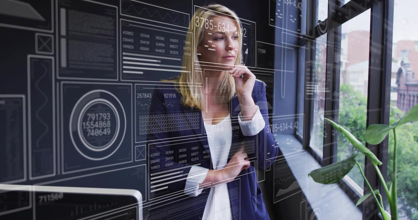 Professional woman monitoring appearing data panels and business metrics while standing by window