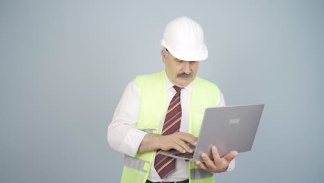 ingeniero con una computadora portátil riéndose de la cámara.