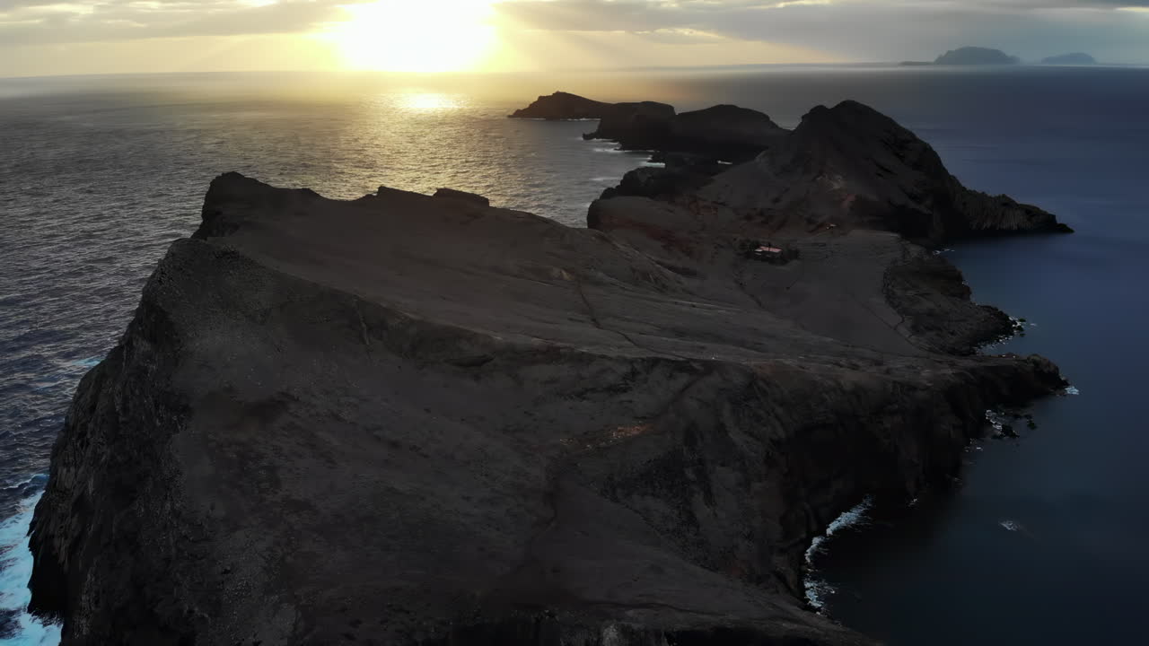Experience the beautiful sunset illuminating the rocky coastline as waves crash against the cliffs. This stunning view captures nature's tranquility and raw beauty at dusk