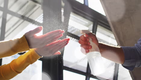 animation of light spots over diverse people disinfecting hands