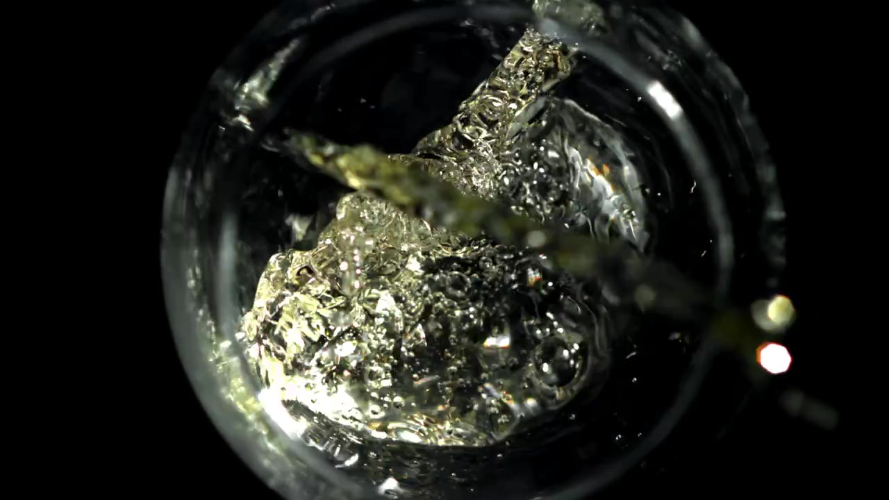 Weißwein in Zeitlupe ins Glas gießen