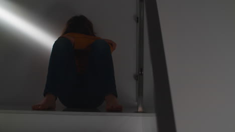 Pensive-teenage-boy-on-staircase-at-home