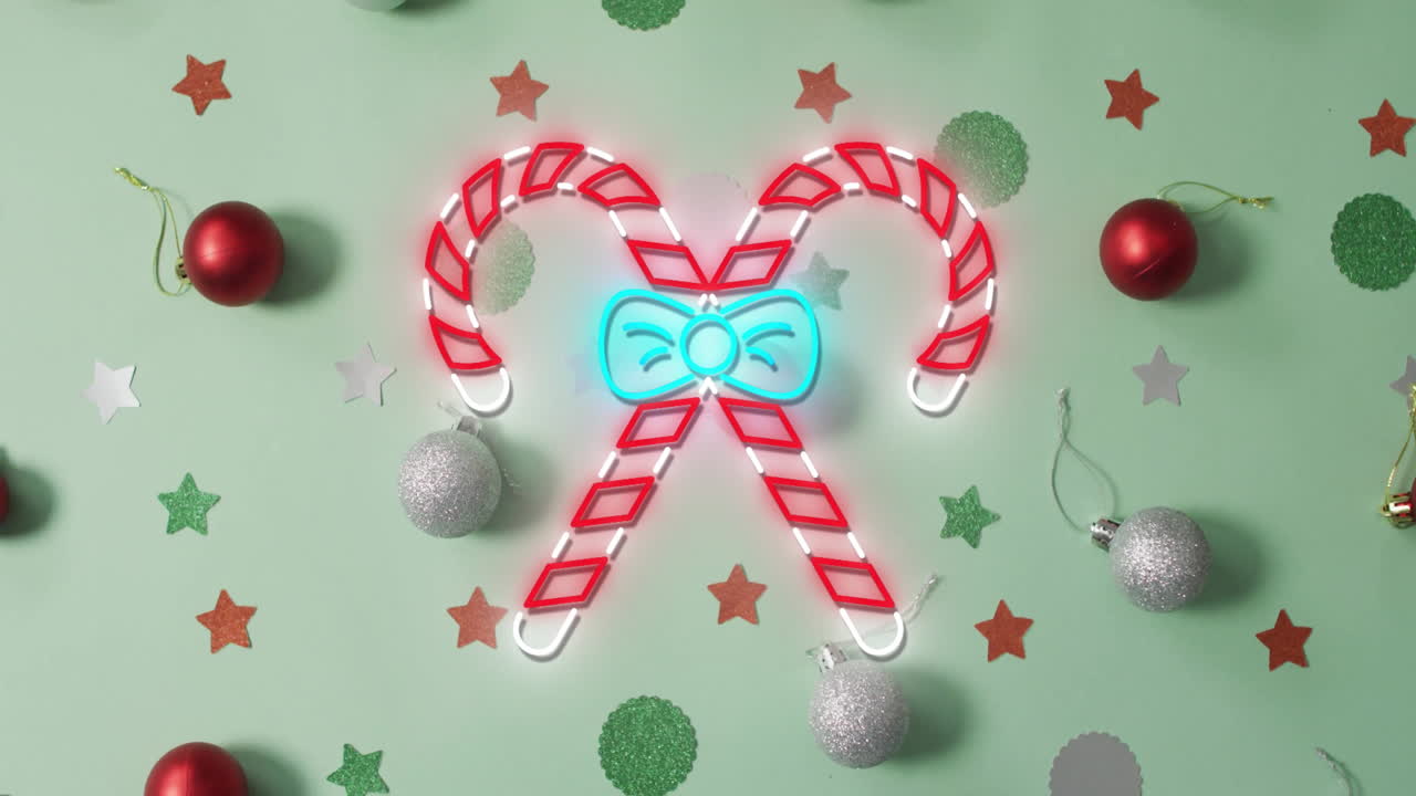Animation of flickering christmas sugar cain over christmas decorations