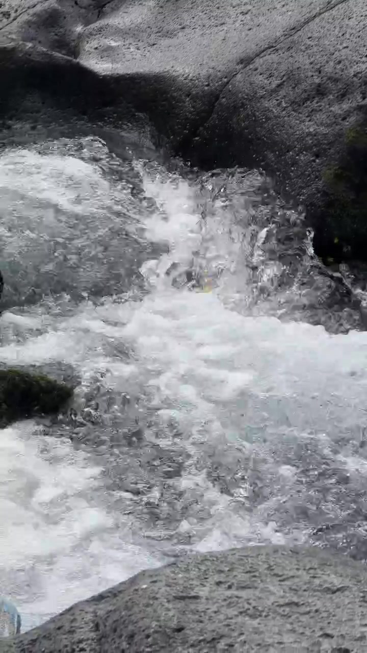 Limpido torrente di montagna che scorre su rocce scure