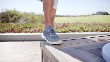 a person is performing step-up exercises on wooden bench outdoors