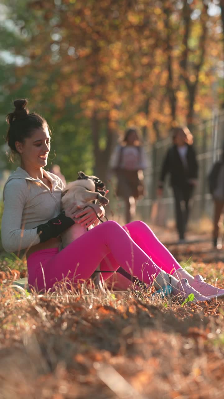 Donna che si gode il parco autunnale con il suo carlino