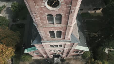 drone en baden-baden alemania vuela hacia arriba desde una boda en alemania a lo largo de la torre de una iglesia