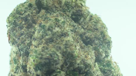 macro primer plano de una marihuana sativa super limón amnesia neblina flores de roca, kush amarillo, verde y púrpura, en un soporte giratorio 360, en un tazón negro brillante, video de cámara lenta 4k