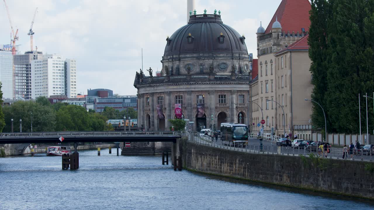 Camera slowly zooms toward Bode Museum and TV Tower, river and cityscape under daylight