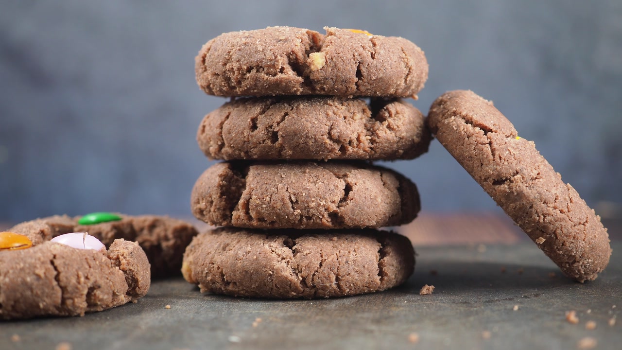 Stack of Chocolate Cookies with Candy on Dark Background
