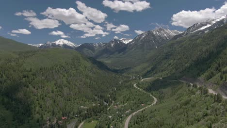 the aerial view moves down to show a view of beautiful winding colorado road