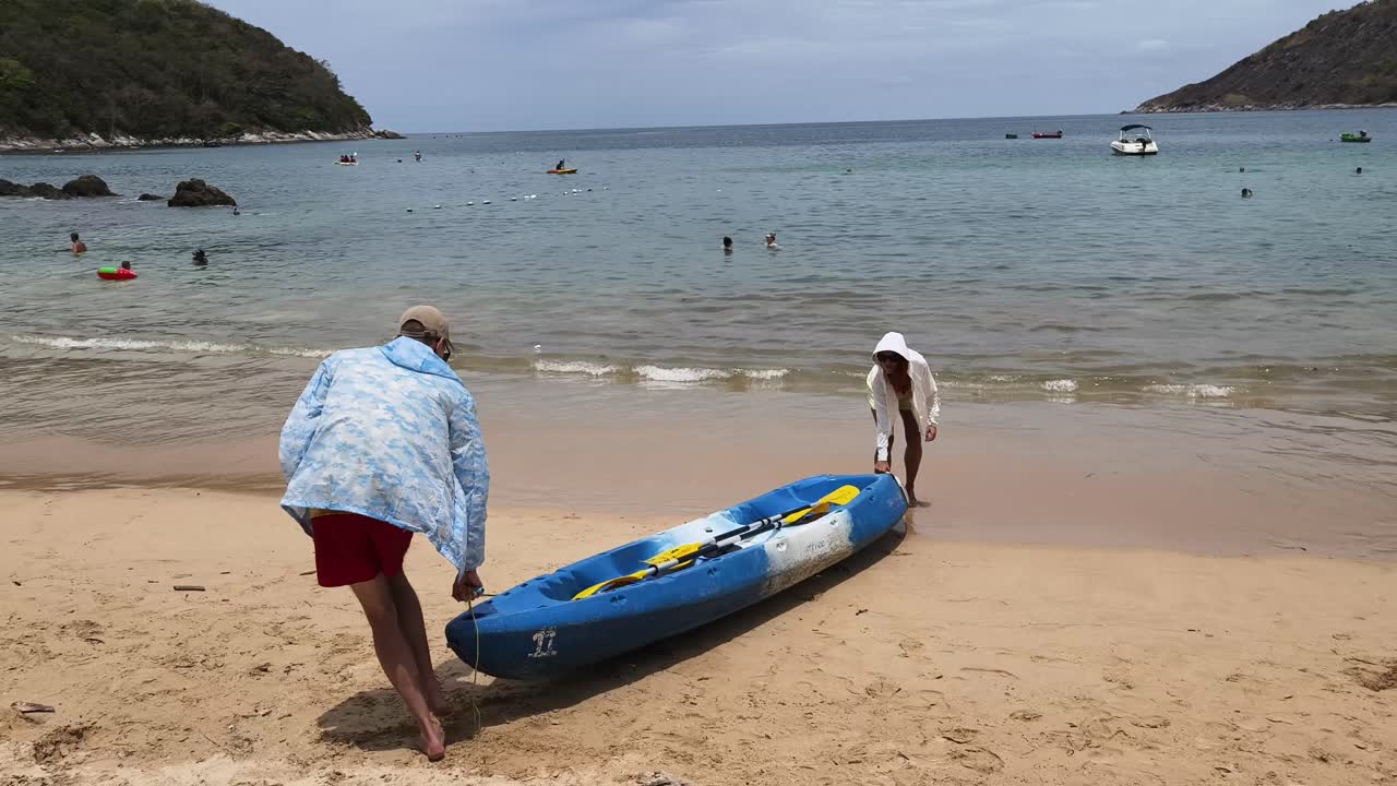 People on Beach with Kayak
