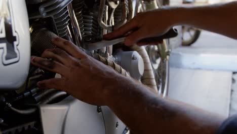male mechanic repairing motorbike in repair garage 4k