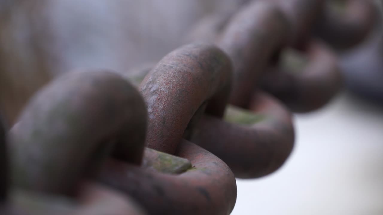 Close up of metal chain links next to a river
