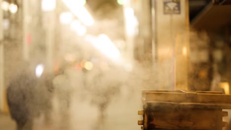 steam rising from pot on busy city sidewalk