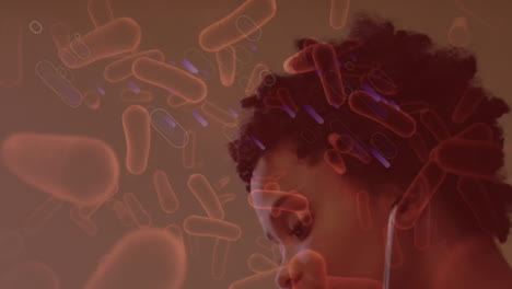 animation of bacteria over african american female doctor checking girl