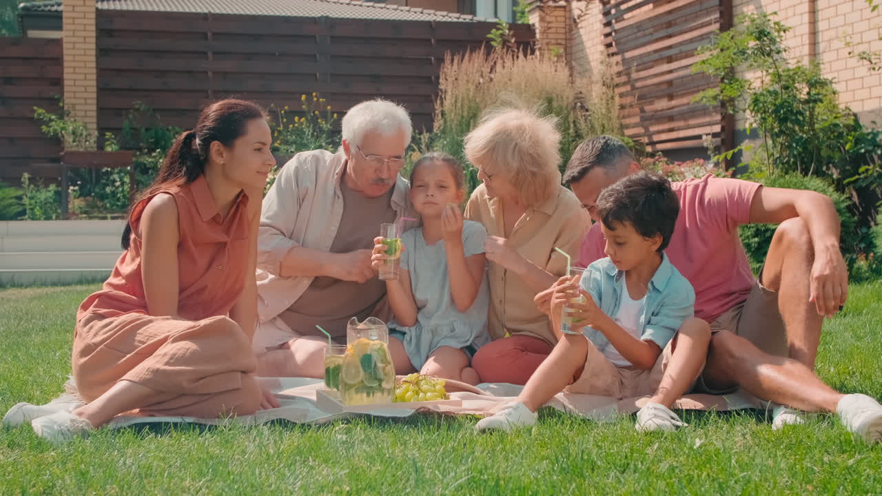 Multigenerational Family Having Picnic In Backyard
