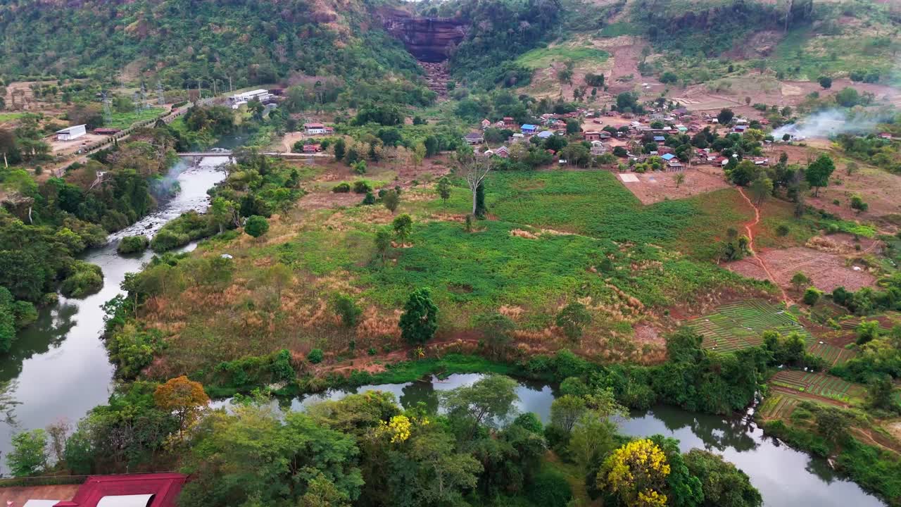 Aerial fly Laos Mekong River across Bolaven Plateau Loop, agricultural landscape, rural mountain village