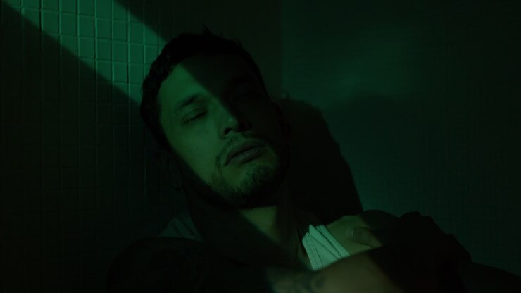 Man in green light and shadow