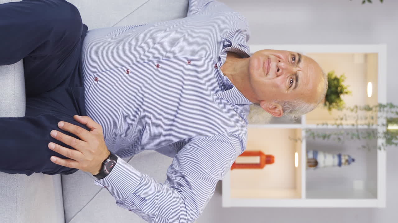 video vertical del anciano esperando impotente en casa. nadie viene y él está solo.