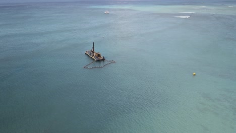 Vista-Aérea-De-La-Barcaza-Frente-A-Waikiki-En-El-Océano-Pacífico-En-Un-Día-Soleado