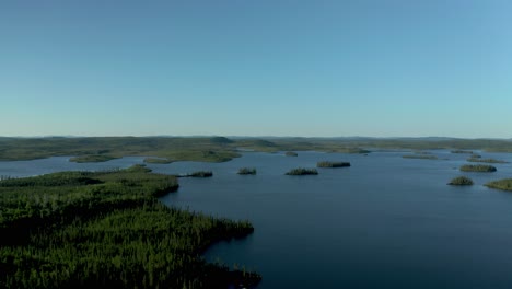 Drone-flying-over-a-beautiful-and-wild-lake-and-forest-on-a-sunny-summer-day