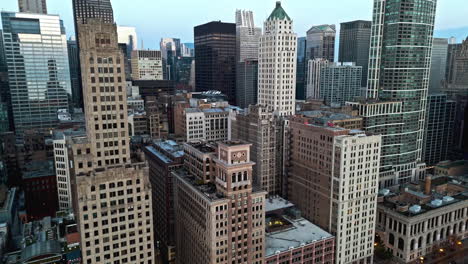 Aerial-view-tilting-toward-high-rise-in-Loop,-autumn-evening-in-Chicago,-USA