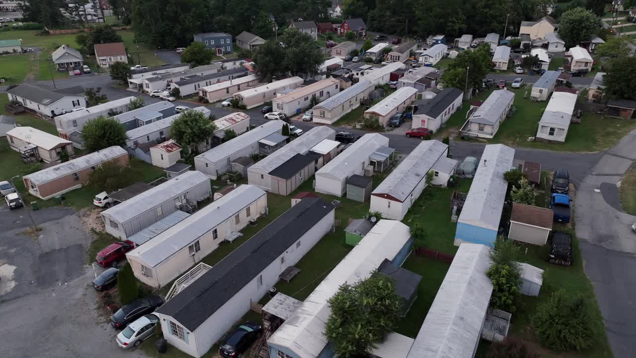 Dense populated mobile trailer home neighborhood in American suburb. Aerial view. Sunset time in American town. Rusty old houses in Low income district of city in Virginia, USA