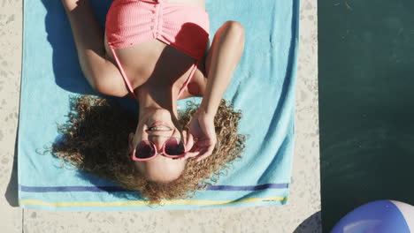 joven de dos razas disfruta del sol junto a la piscina