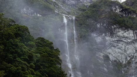 Teleobjetivo-Aéreo-De-Niebla-Y-Nubes-Que-Oscurecen-La-Cascada-Que-Cae-Por-La-Escarpa-De-Milford-Sound