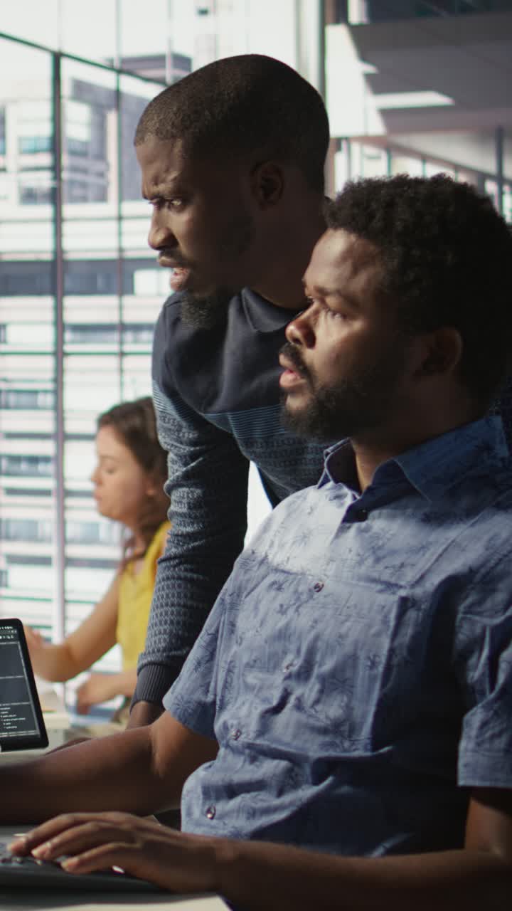 Vertical video Admin assisted by coworker while working with machine learning