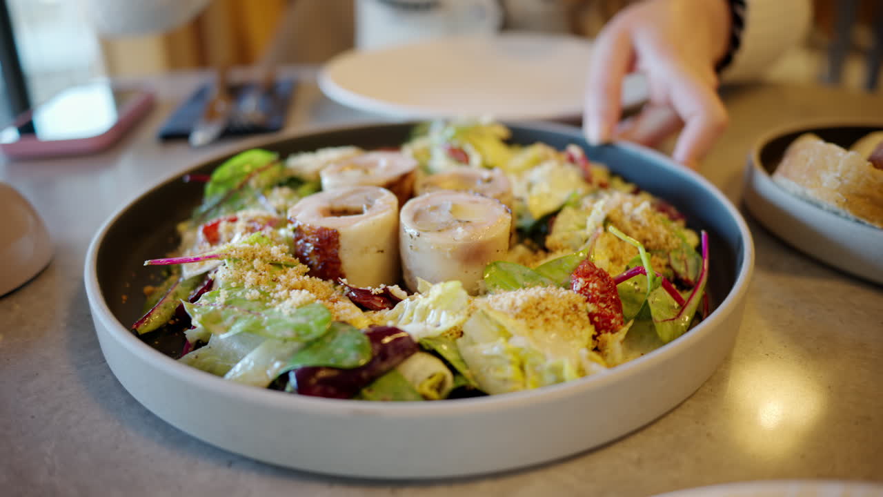 Woman presenting a salad at a restaurant